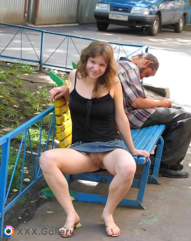 Trashy teen flashing pussy while the homeless man sleeping behind her